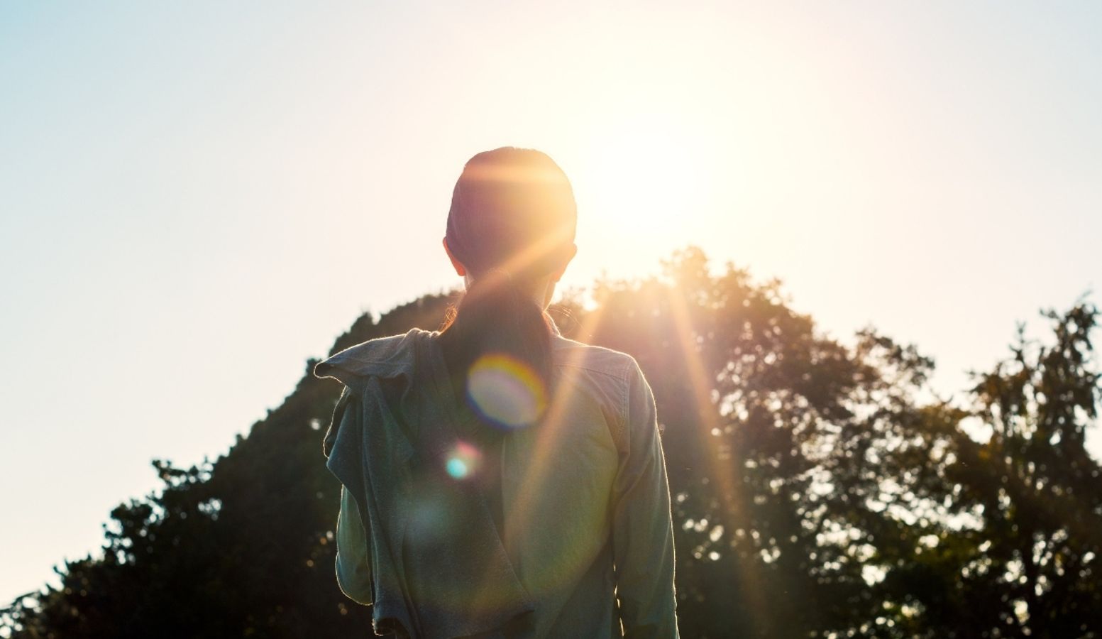 Person utendørs i sollys – solens UVB-stråler bidrar til kroppens produksjon av vitamin D.